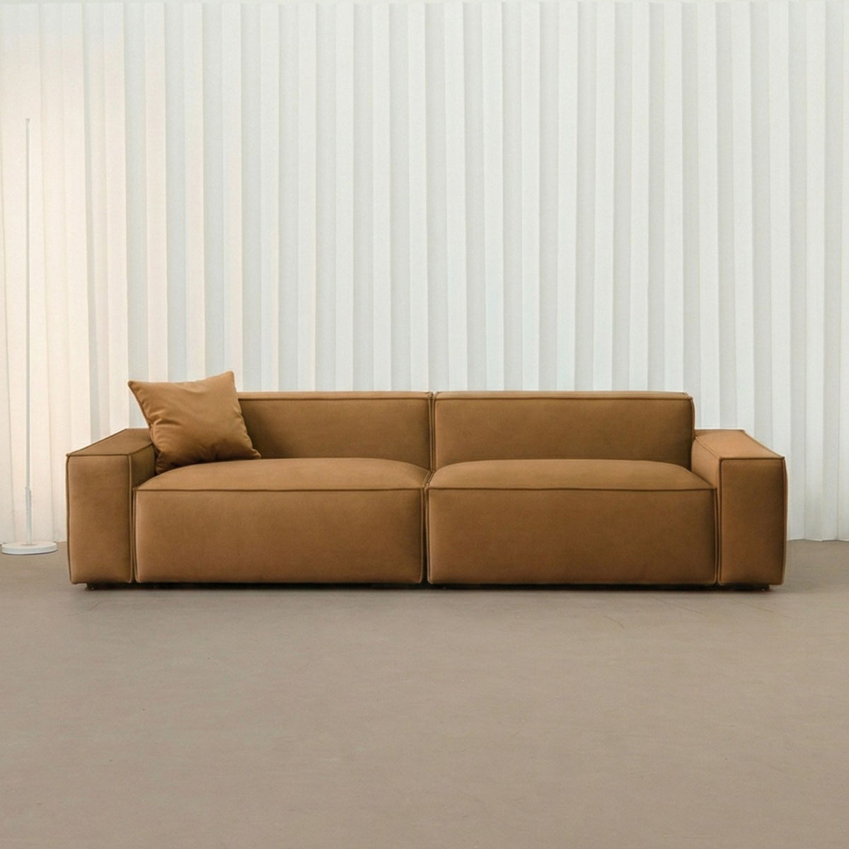 Brown sofa in a minimalistic room with white curtains