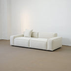 White sofa in a minimalistic room with a plain white wall.