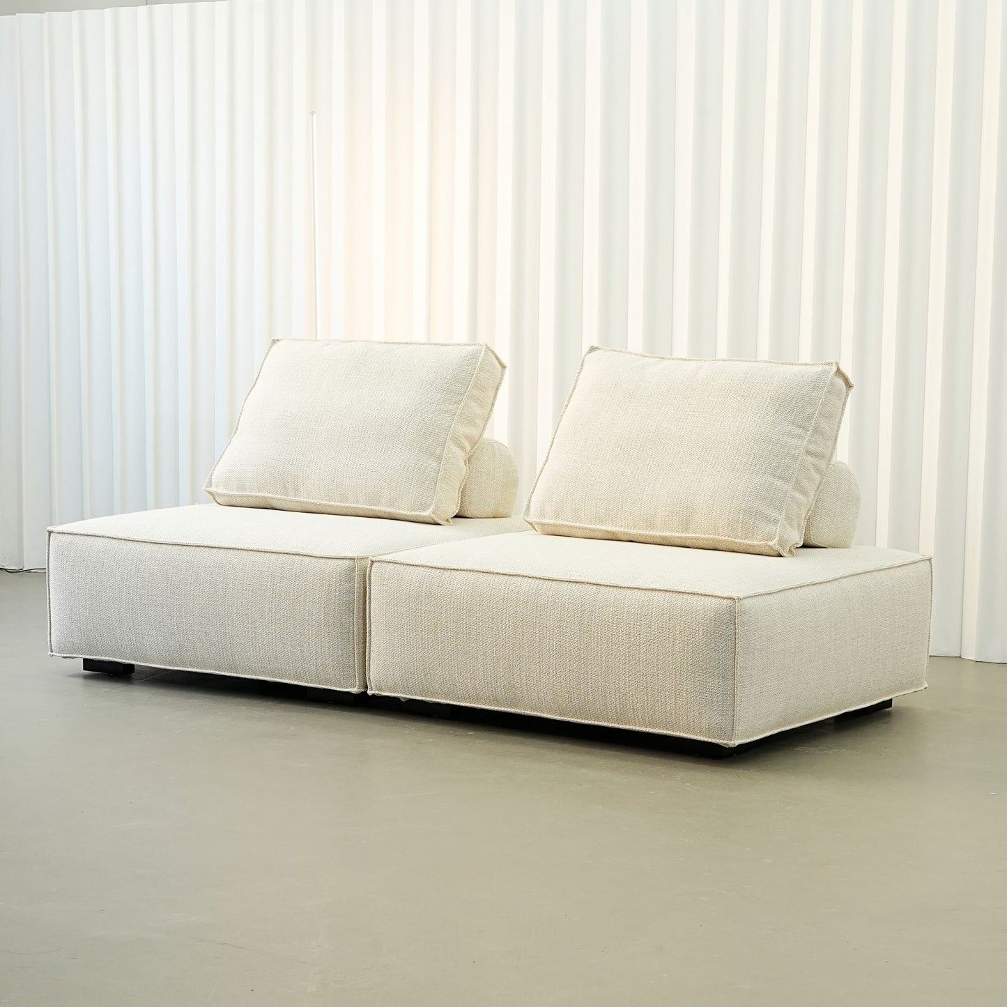 White sofa with cushions on a plain background
