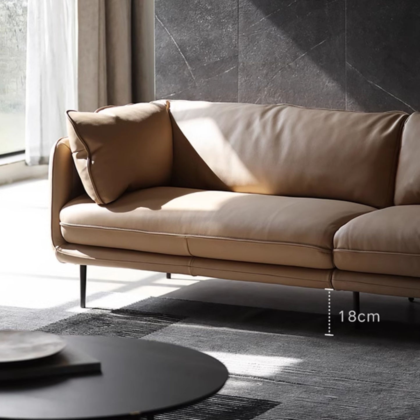 Close up view of cuddle leather sofa in beige, highlighting its leg height at 18cm
