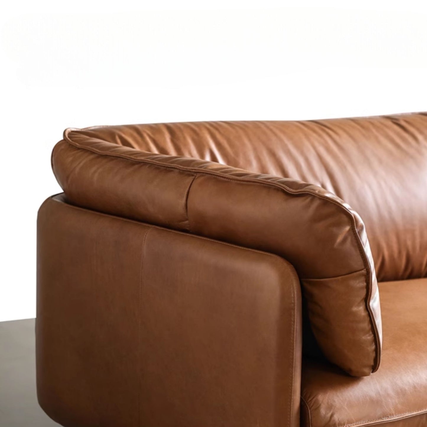 Close up view of Cuddle brown leather sofa armrest and backrest cushion portion