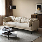 White sofa in a living room with a coffee table and lamp.