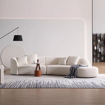 Modern living room with a white sofa, coffee table, and decorative items.