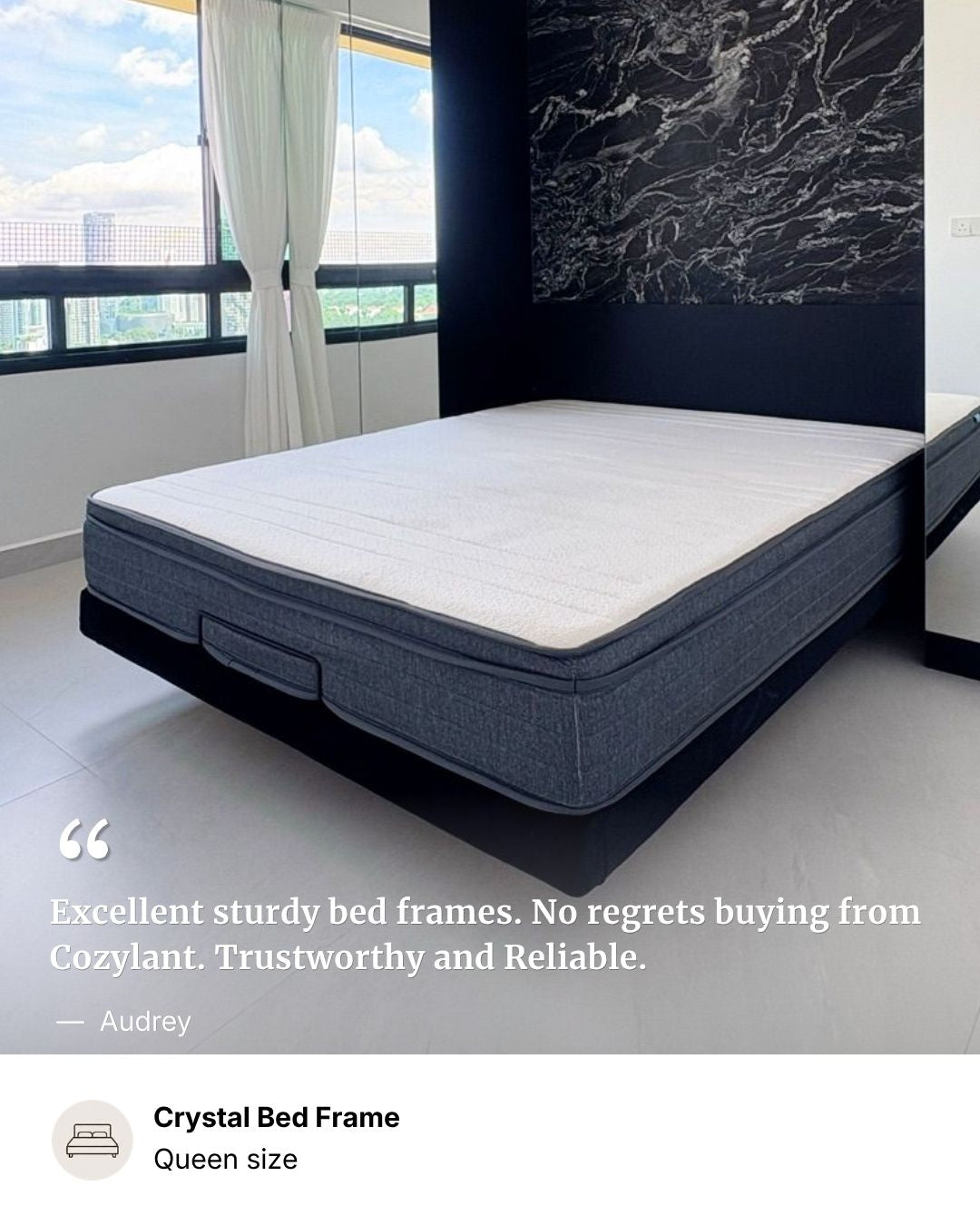 A high-quality mattress shown on a bed frame in a modern bedroom setting. The mattress has a white top surface and a dark gray textured side panel, resting on a black bed frame.