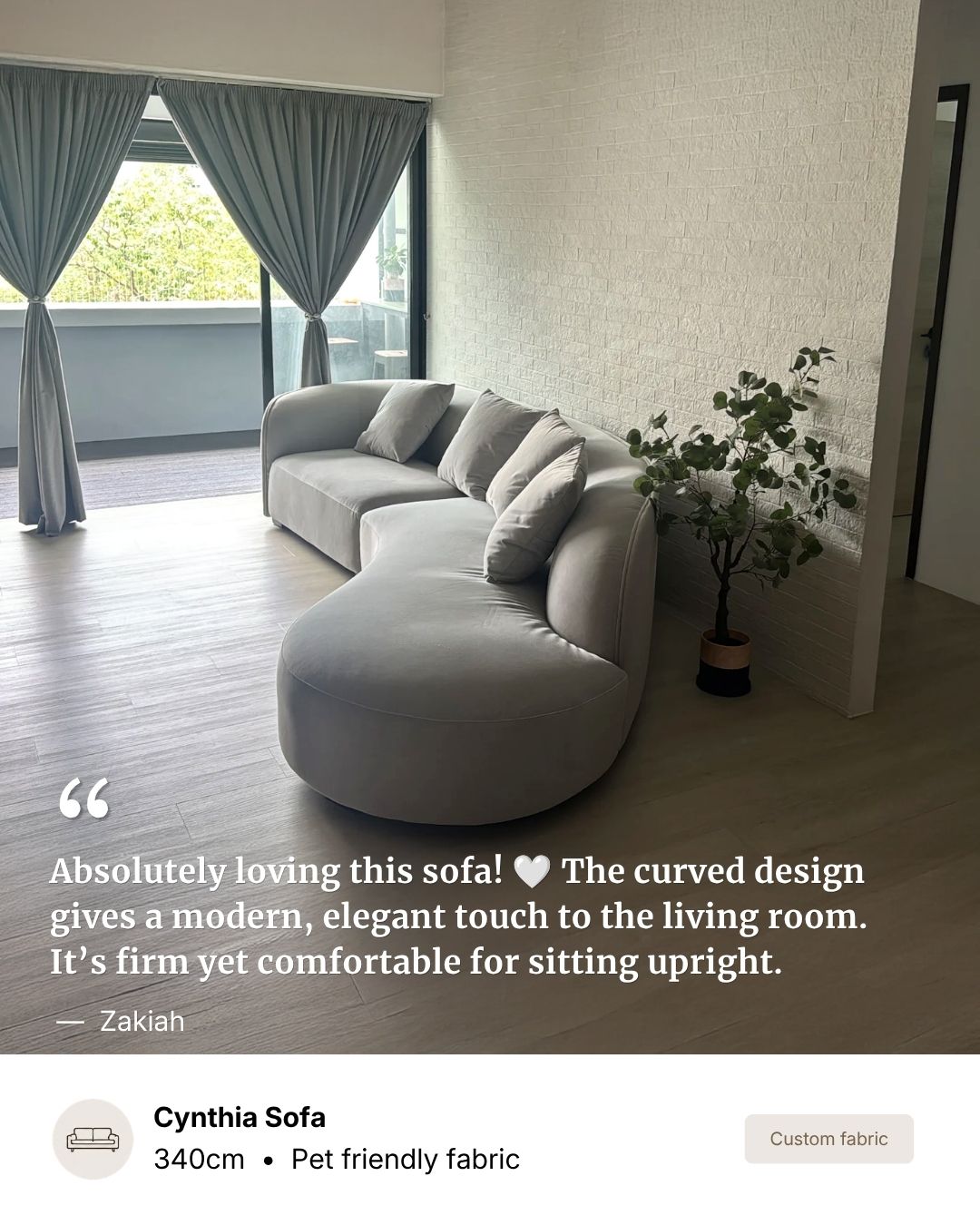 A curved light gray pet-friendly fabric sofa in a modern living room setting, with a potted plant, curtains, and a text overlay describing the sofa's features.