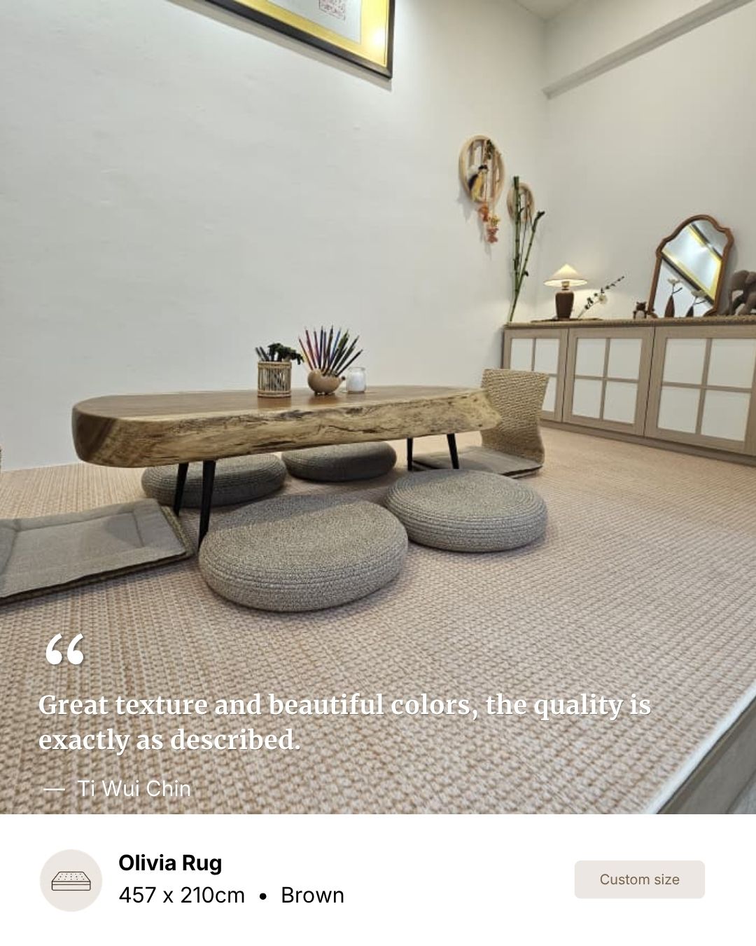 A low wooden coffee table with a live edge and black metal legs, surrounded by round gray poufs on a textured beige rug in a modern, minimalist room.