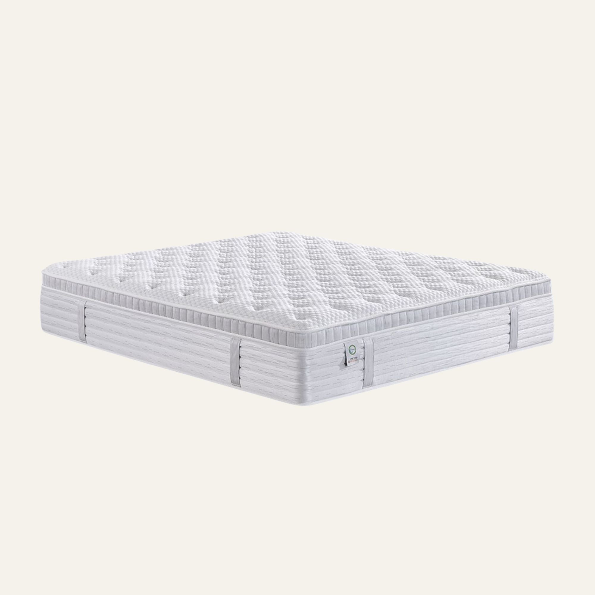 A white quilted mattress shown from a three-quarters perspective against a solid light beige background.