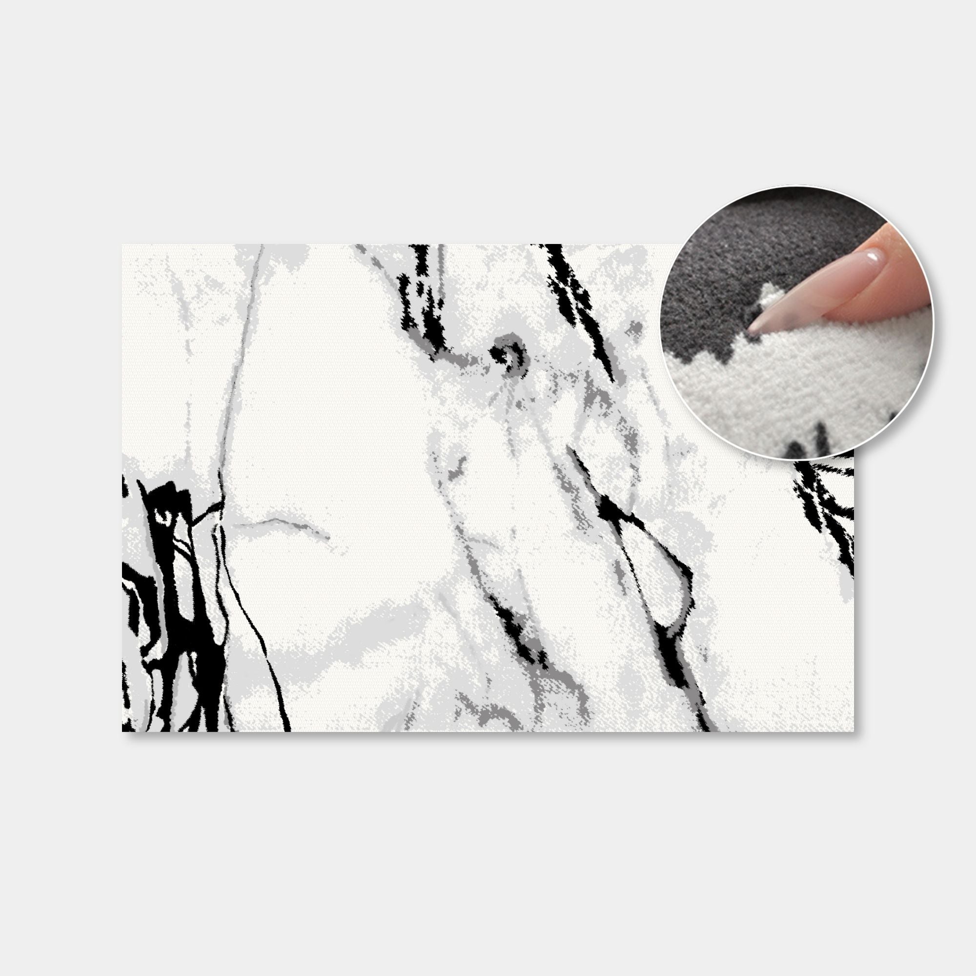 A rectangular rug or mat with a black and white marble pattern, shown on a light gray background with a circular inset demonstrating the soft, plush texture of the material.