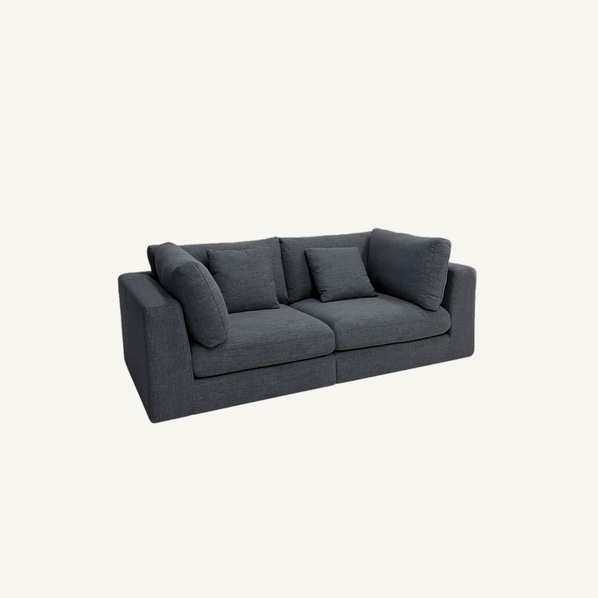 A modern three-seater sofa upholstered in dark gray textured fabric, featuring two matching throw pillows, shown against a plain off-white background.