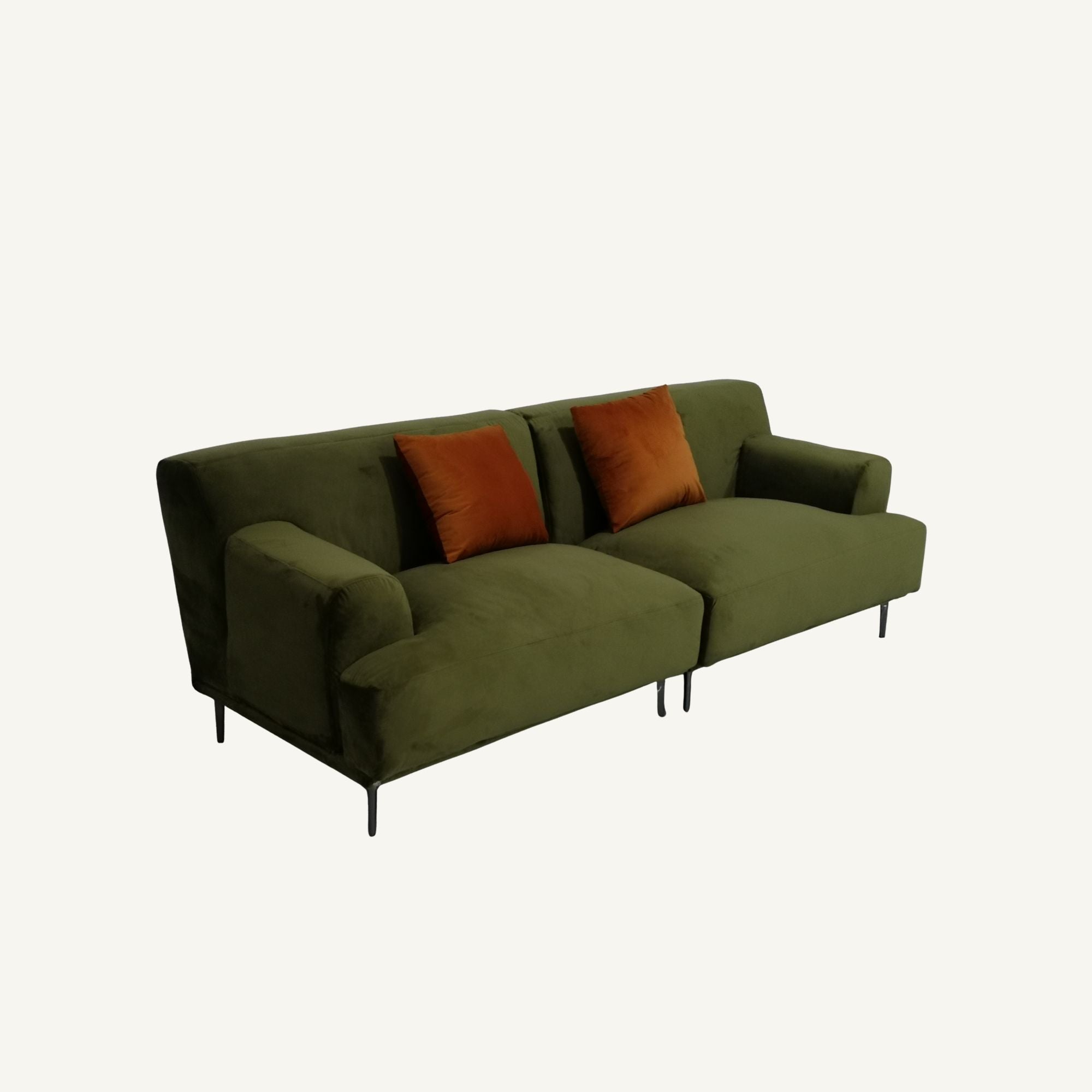 An olive green velvet loveseat sofa with two rust-orange throw pillows and slim black metal legs, shown against a plain off-white background.