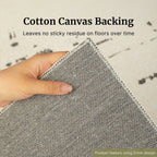 Hand holding gray fabric with text about cotton canvas backing