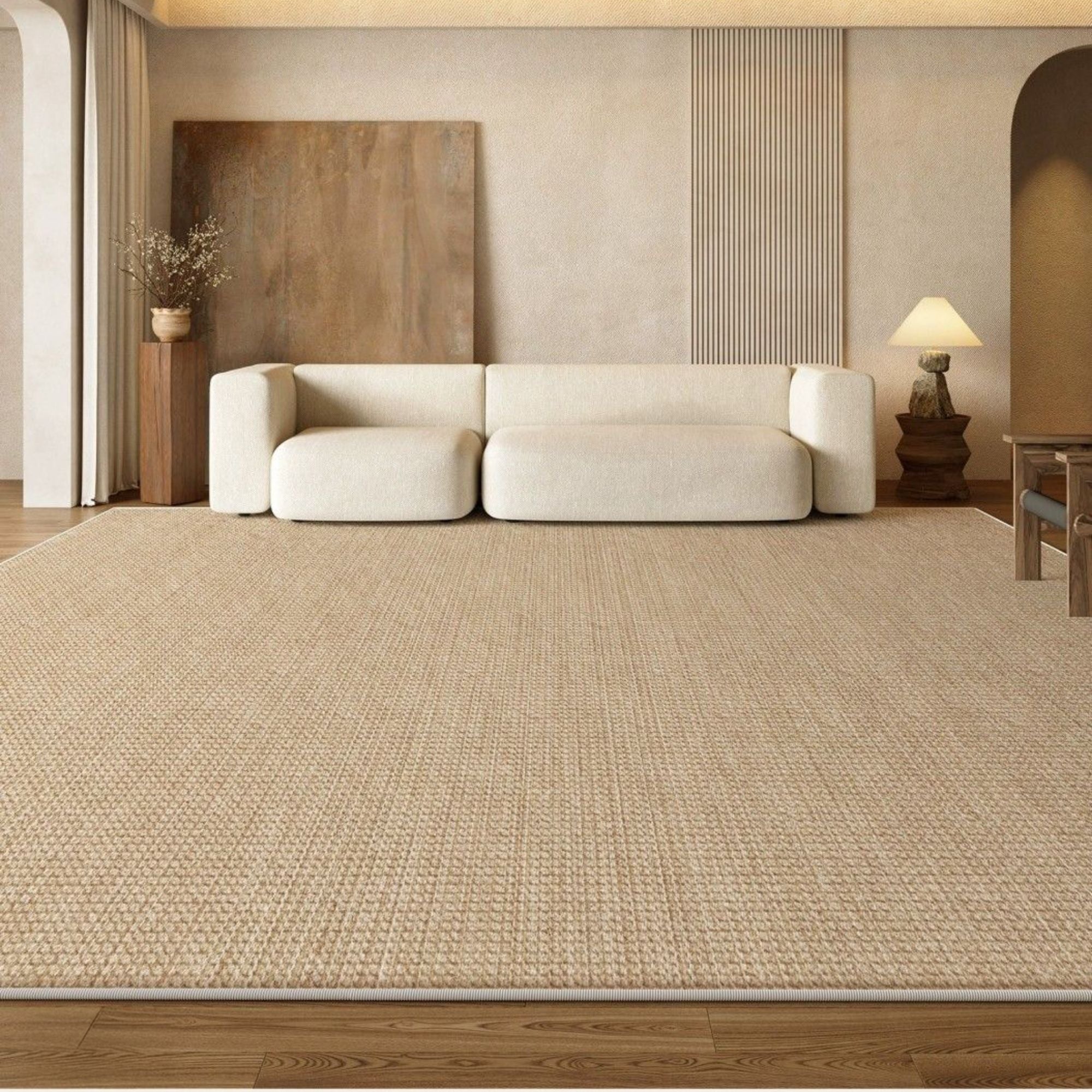 Beige textured rug in a living room with a white sofa and wooden furniture.