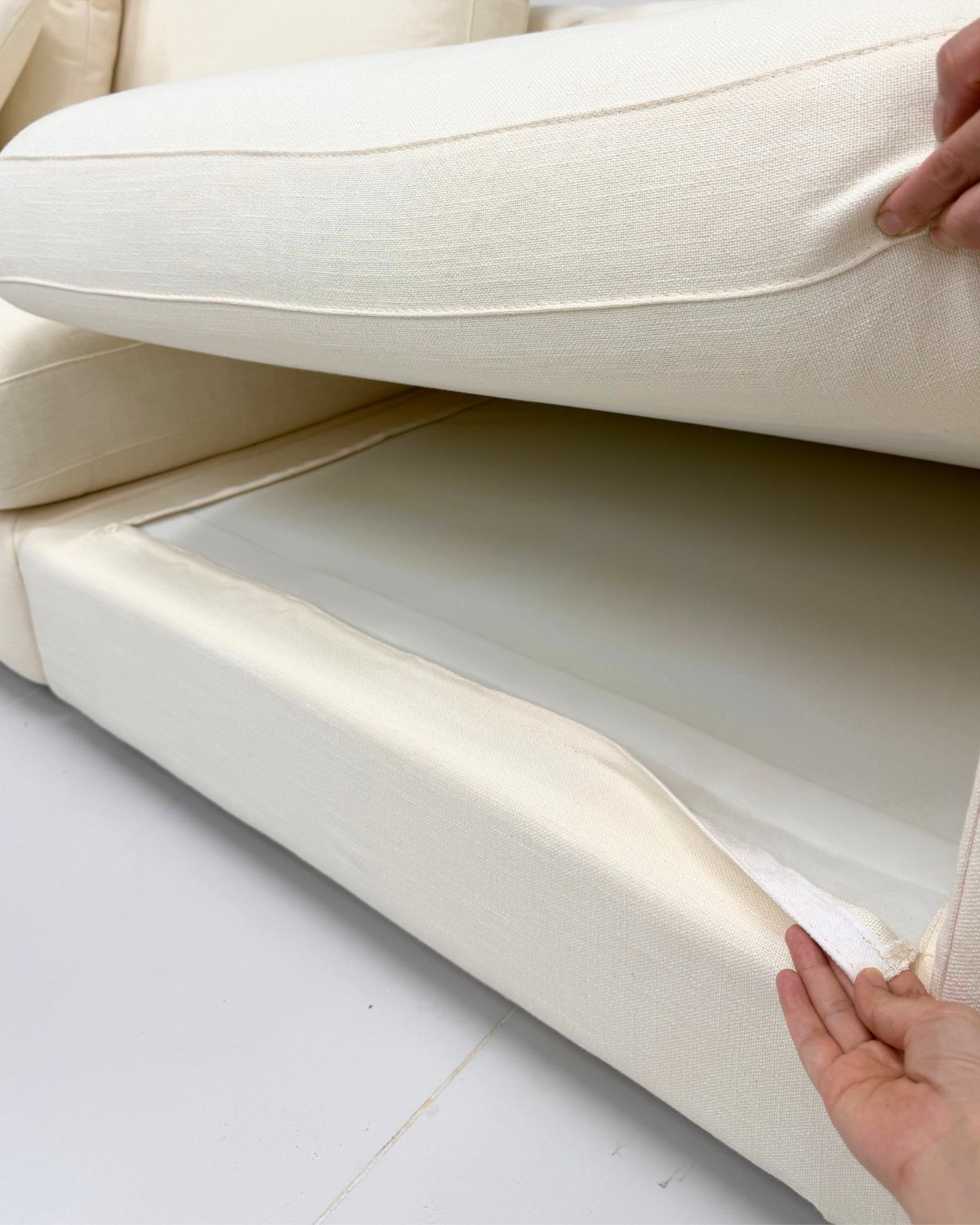 White sofa with a person removing the frame fabric cover, labeled 'Removable Cover Sofas'.