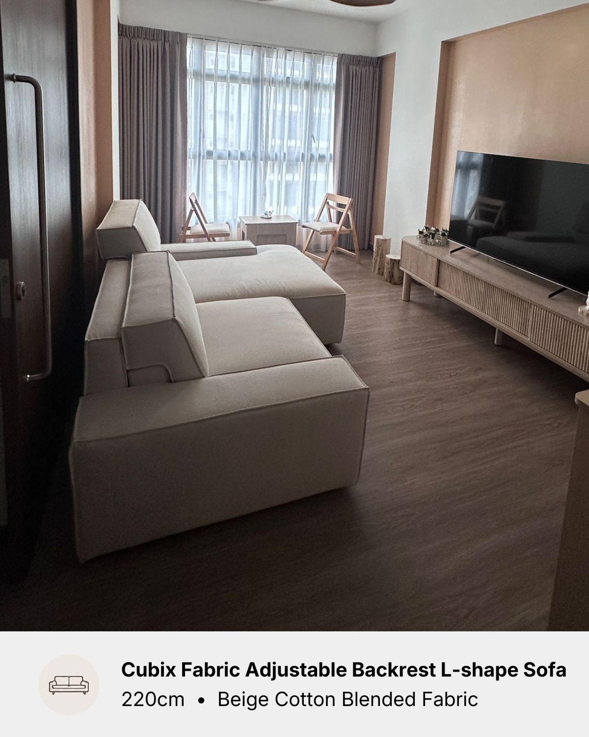 A beige fabric L-shaped sectional sofa with an adjustable backrest, shown in a modern living room setting with dark wood flooring and a TV console.