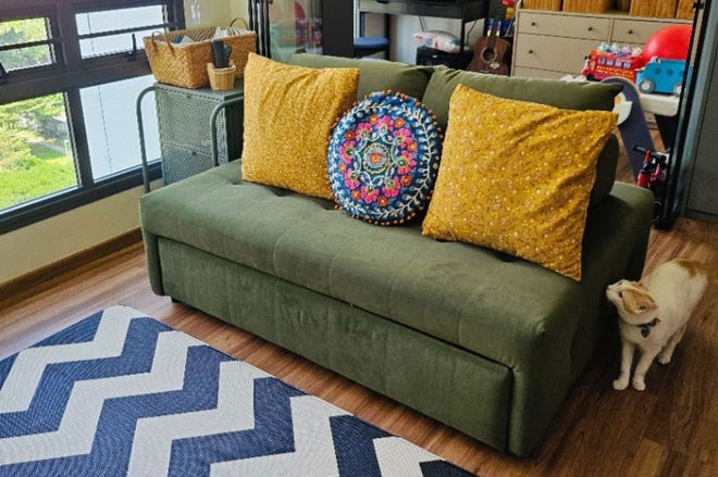 Sample of a cat near Candy fabric sofa bed upholstered in green pet friendly fabric and it is unable to go underneath the sofa due to low sofa legs