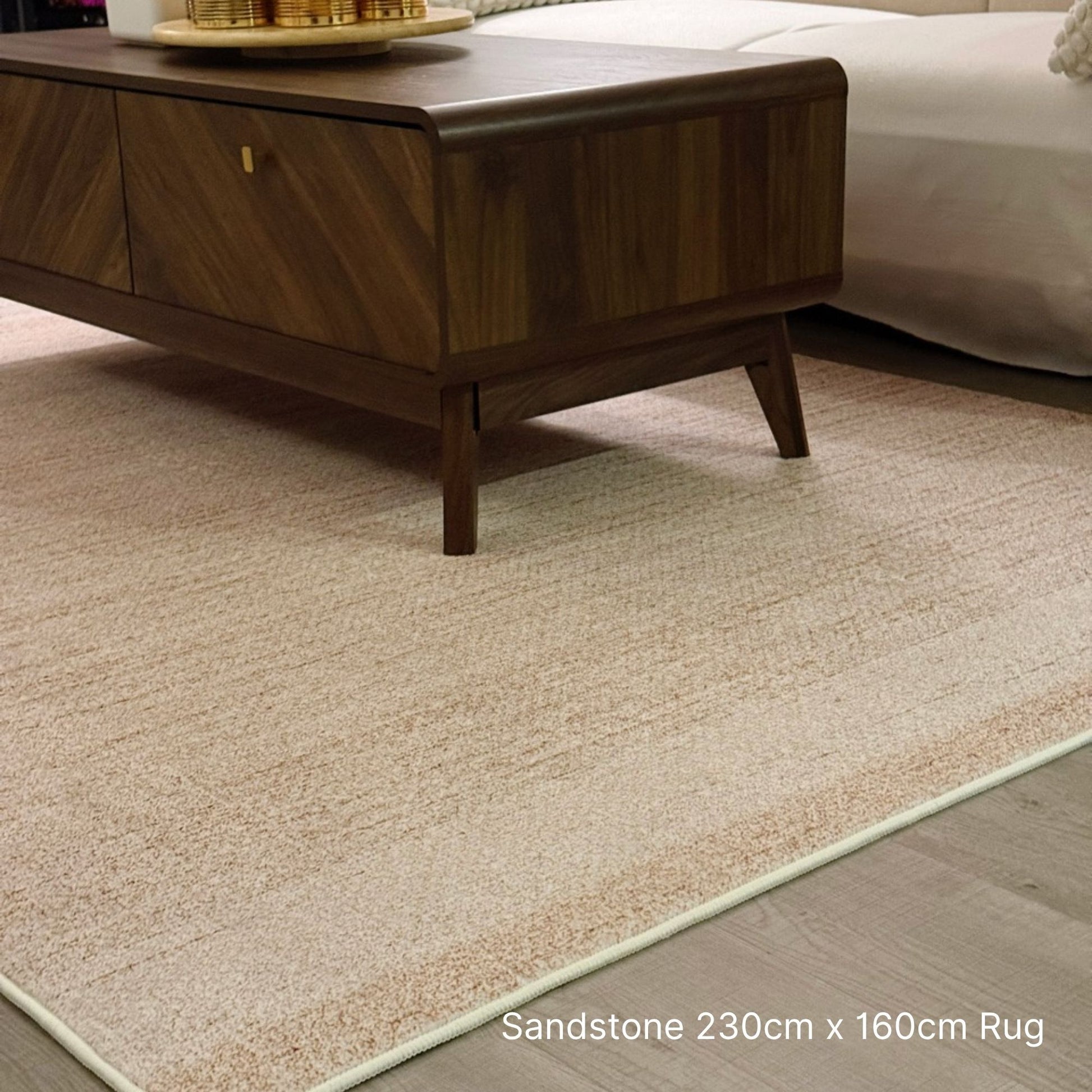 Beige rug on a wooden floor with a coffee table in the background