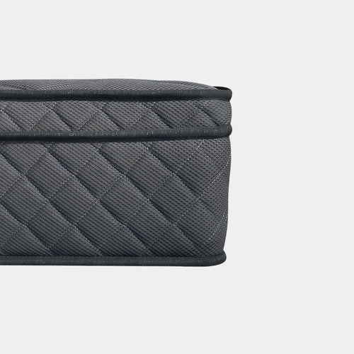 Close-up of a dark gray quilted fabric mattress with a textured woven pattern and black trim, shown against a light gray background.