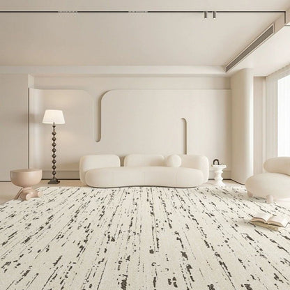 Modern living room with a white sofa, lamp, and rug.