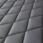 Close-up of a dark gray quilted mattress or cushion surface with a textured diamond pattern.