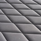 Close-up of a dark gray quilted mattress topper with a textured diamond pattern.