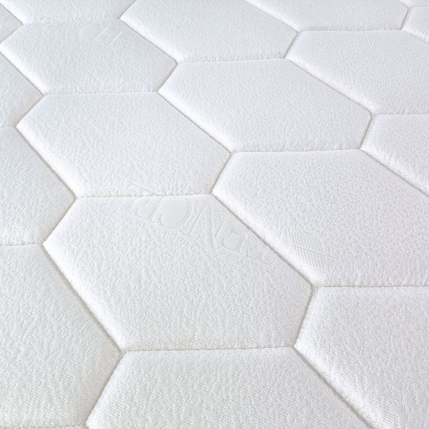 Close-up of white hexagonal tiles arranged in a pattern which is the top cover pattern for Stellar mattress