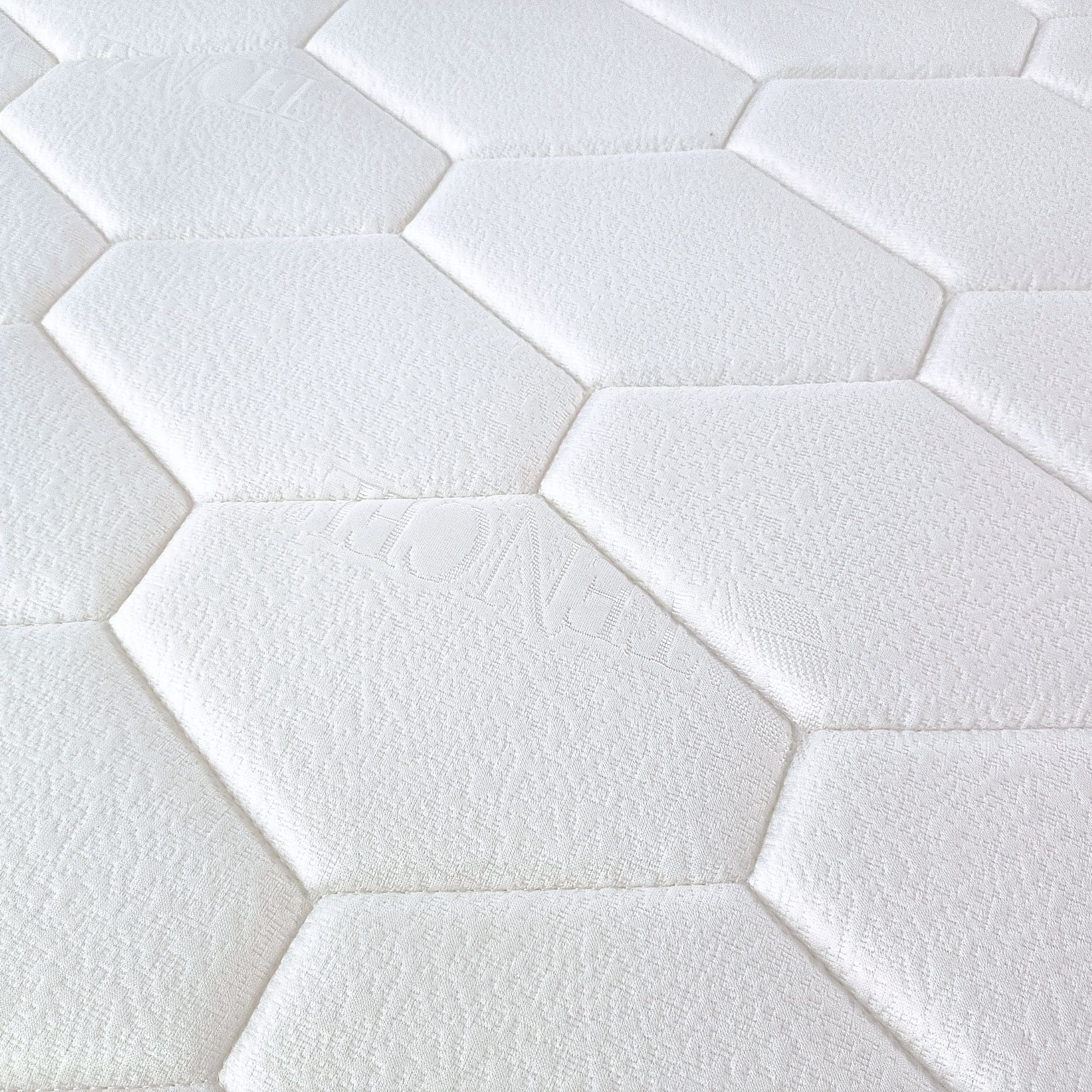 Close-up of white hexagonal tiles arranged in a pattern which is the top cover pattern for Stellar mattress