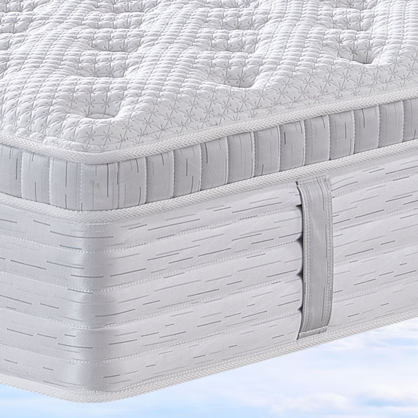 Close-up of a mattress with a quilted top layer on a light blue background
