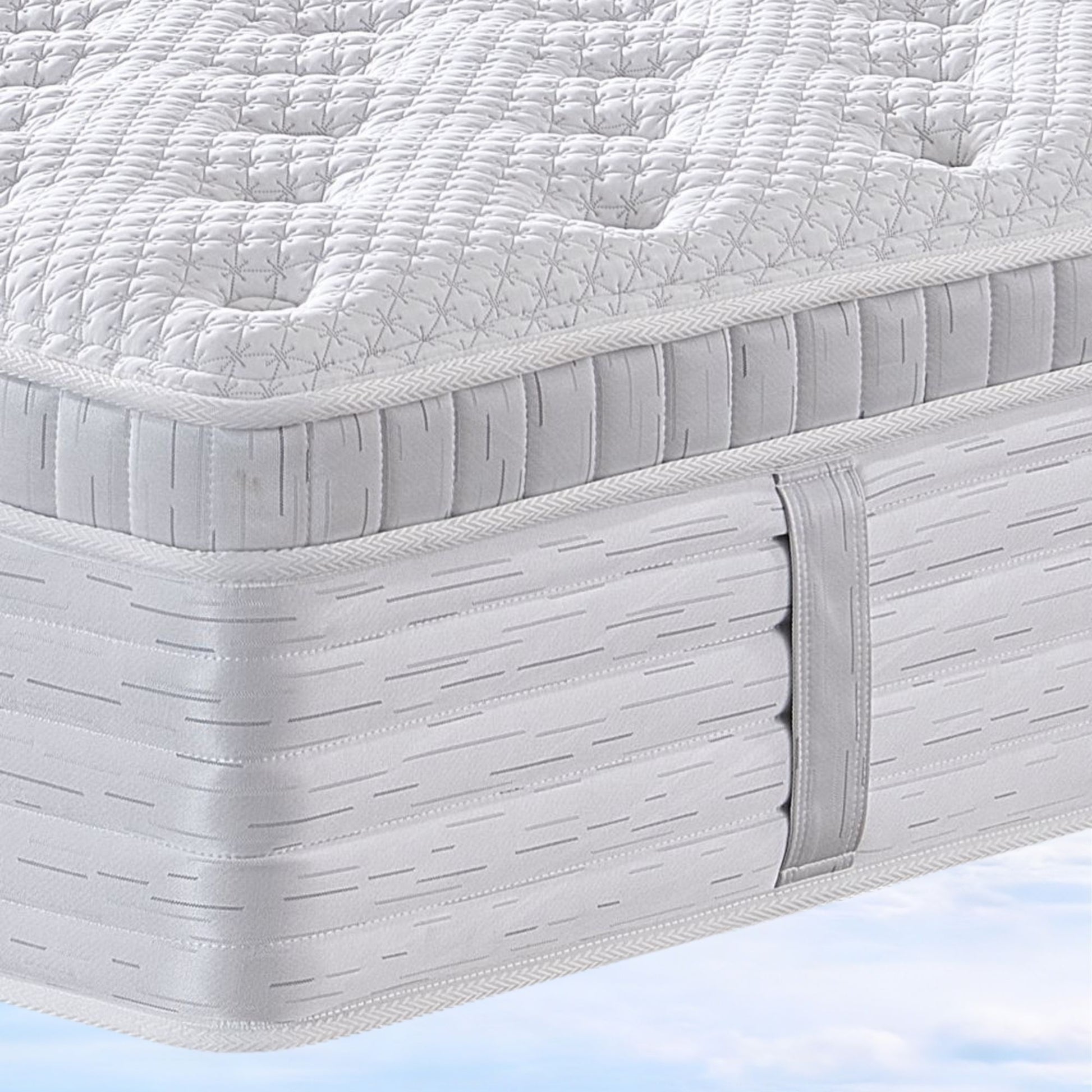 Close-up of a mattress with a quilted top layer on a light blue background