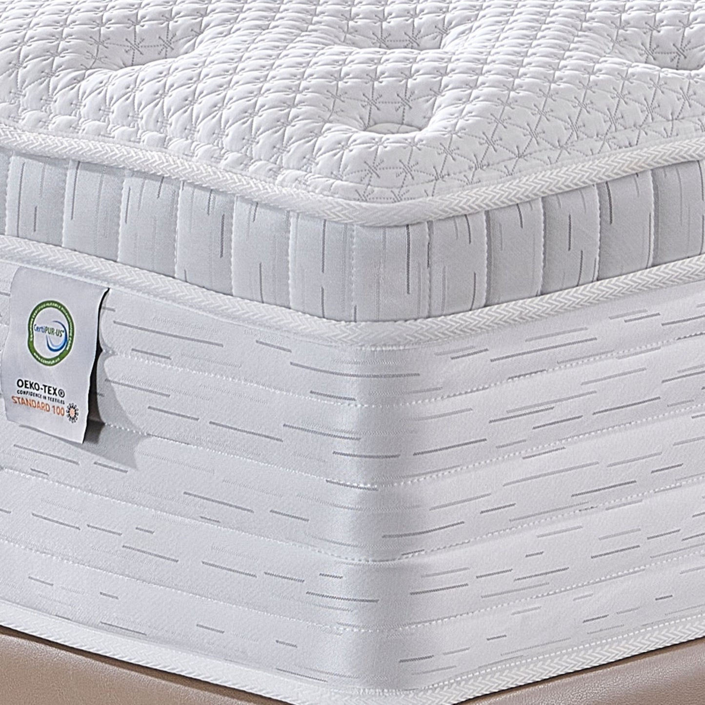 Close-up of a white mattress with a oeko-tex and certipur-us certification on a neutral background