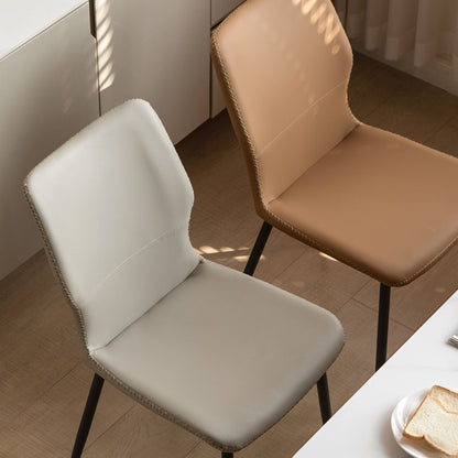 Two chairs, one brown and one gray, in a room with a table and bread.