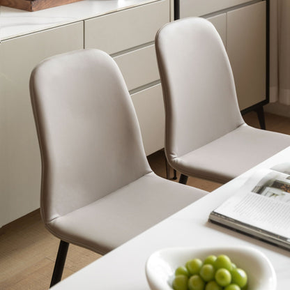 Two grey chairs at a dining table with a bowl of grapes and a magazine.