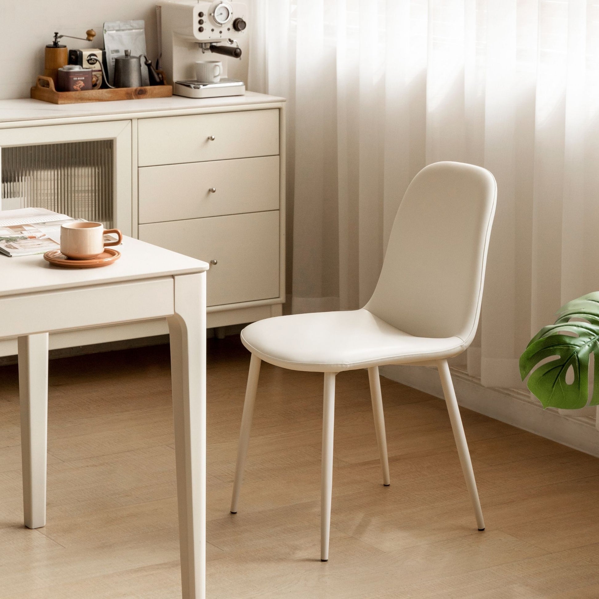 White chair in a room with a desk and cabinets.