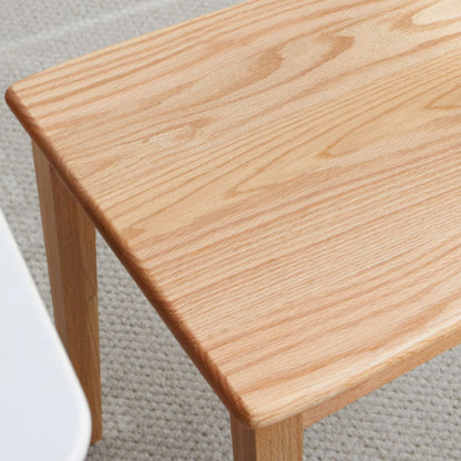 Close-up of a wooden table corner on a carpeted floor