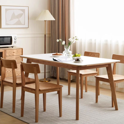 Dining room with wooden table and chairs, lamp, and decor.