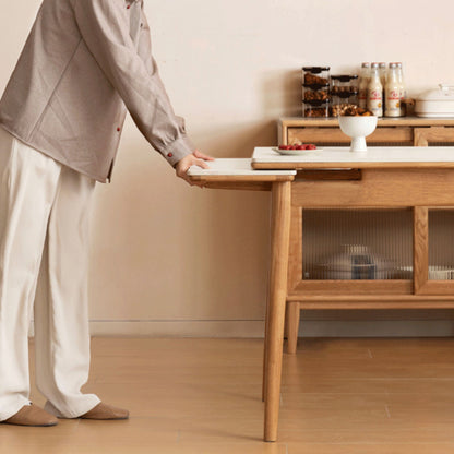 Person adjusting a wooden table in a room with a shelf and food items.