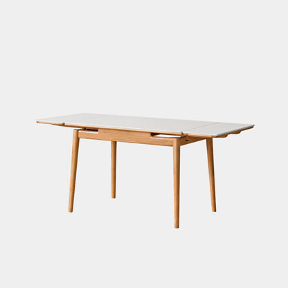 Dining table with white top and wooden legs on a light gray background