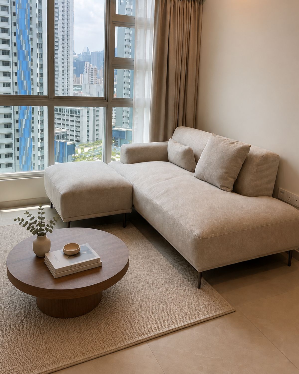 Grey single arm sofa with ottoman in a living room with a window